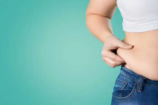 Image of woman pinching her love handles to show weight gain Solihull Lodge